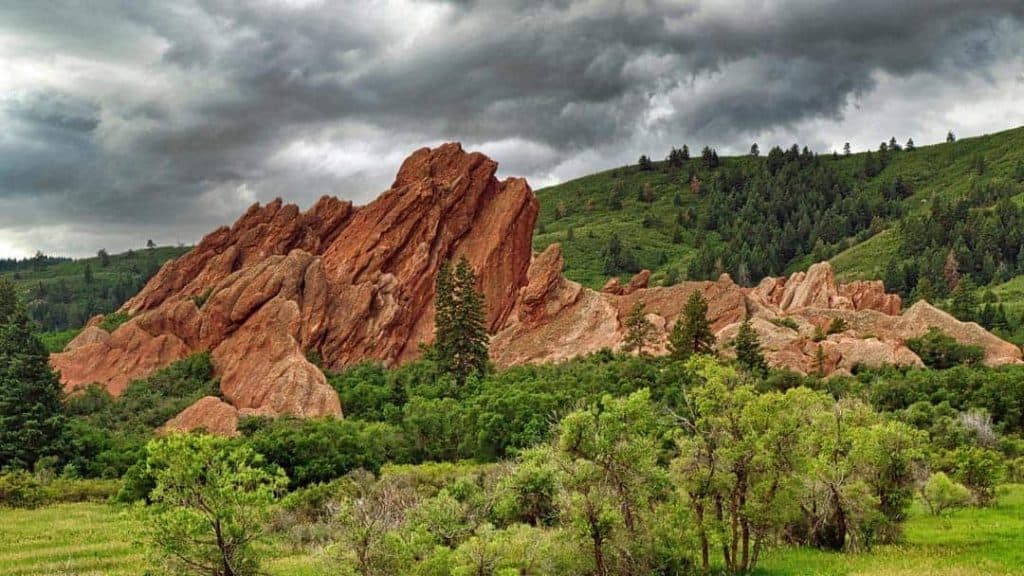 Dark storm clouds moving in over the striking red sandstone fountain formations at Roxborough State Park, Colorado.