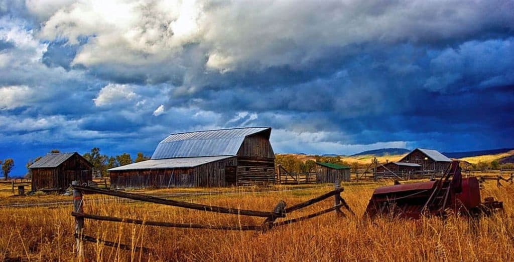 A dramatic sky highlights the old barns of Mormon Row in Grand Teton National Park, Wyoming.