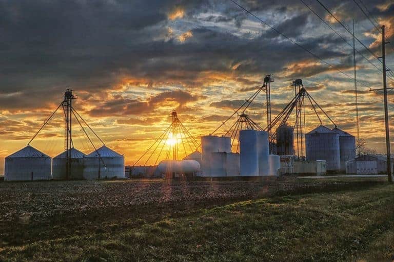 A dramatic rural central Illinois winter sunset over grain bins and silos.