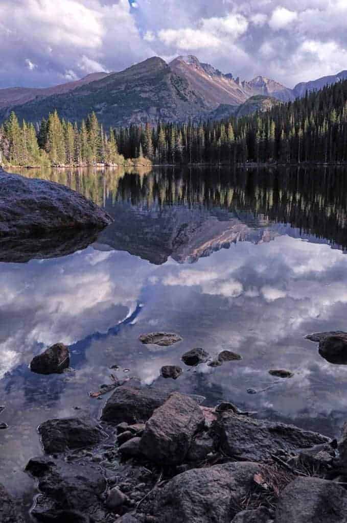 The only mountain risking above 14,000 in Rocky Mountain National Park, Longs Peak is reflected in the glass-like water of Bear Lake on a cloudy autumn evening.