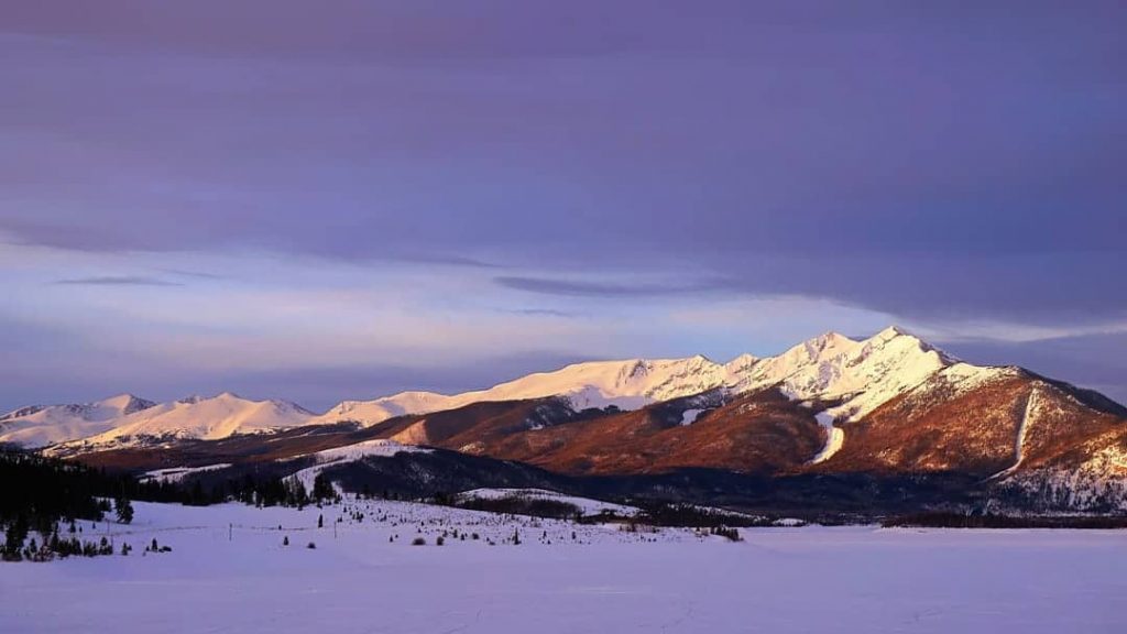 A moody "blue-hour" sunrise as the first light of day hits the rugged peaks of the Ten Mile Range in Summit County, Colorado.