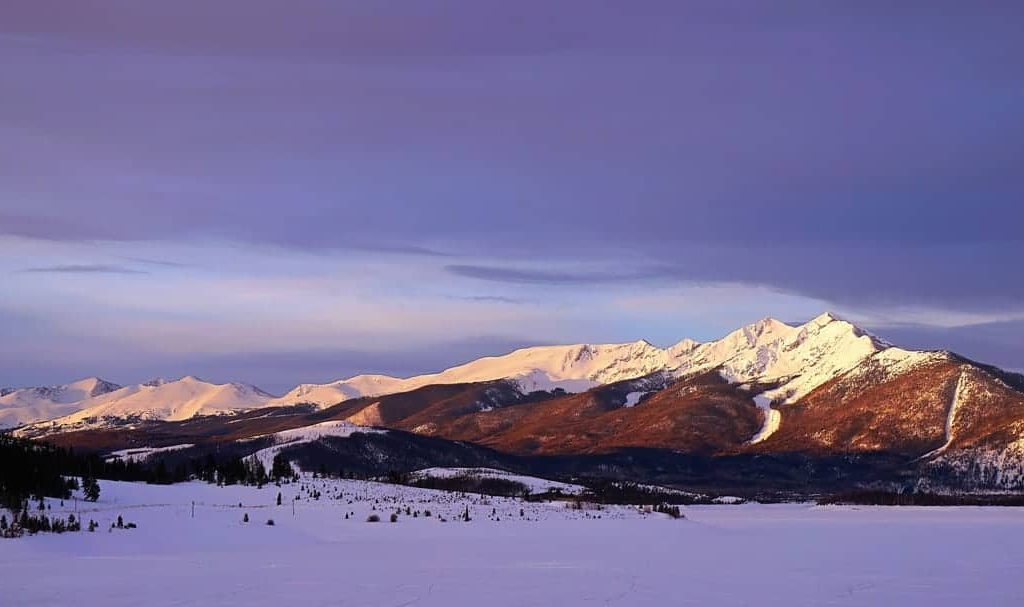 A moody "blue-hour" sunrise as the first light of day hits the rugged peaks of the Ten Mile Range in Summit County, Colorado.