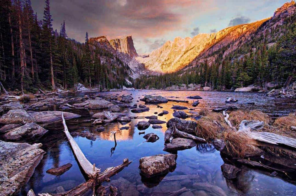 Dramatic dawn light and colorful skies reflected in Dream Lake in Rocky Mountain National Park, Colorado.
