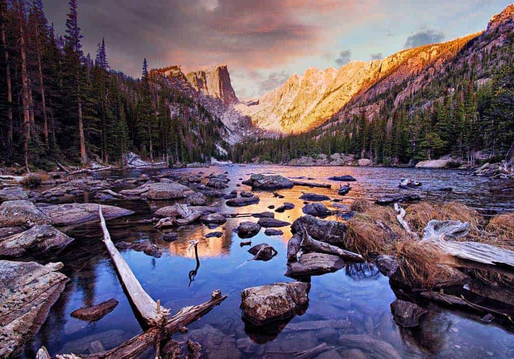 Dramatic dawn light and colorful skies reflected in Dream Lake in Rocky Mountain National Park, Colorado.