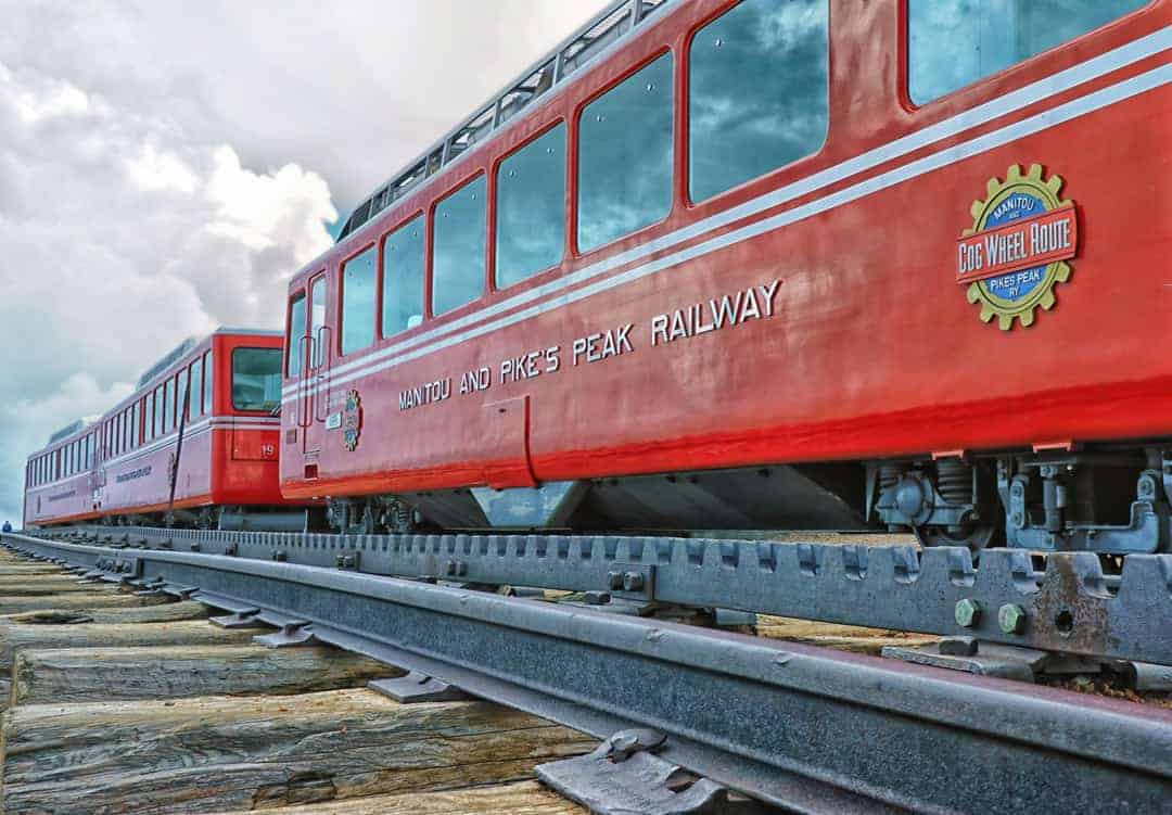 The bright red cars of the Pike's Peak Railway cog train at the summit of 14,115' Pike's Peak near Colorado Springs, Colorado.