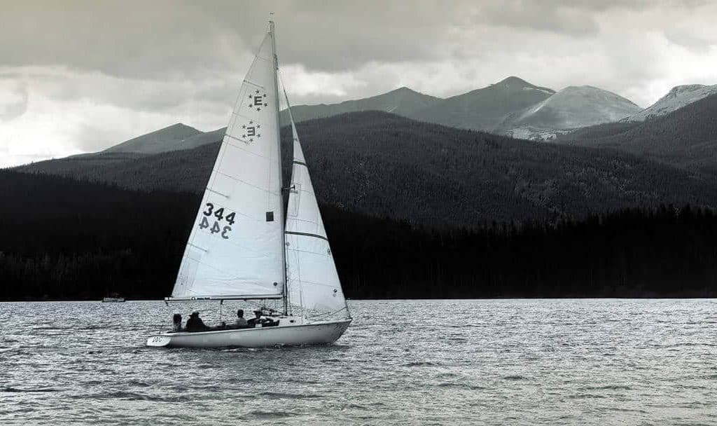 Lone sailboat crosses high altitude Lake Dillon in Summit County Colorado.