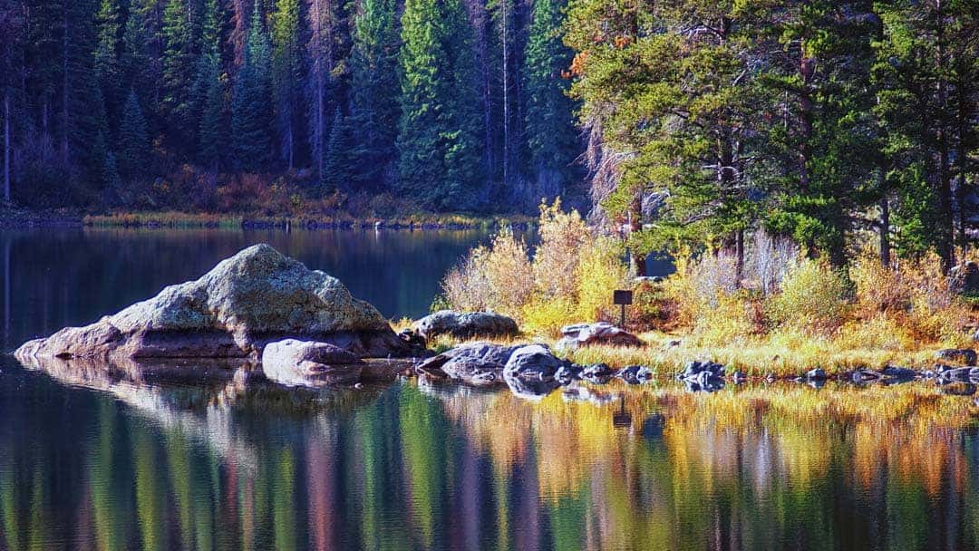 Monarch Lake reflects autumn colors of shoreline on early fall morning.