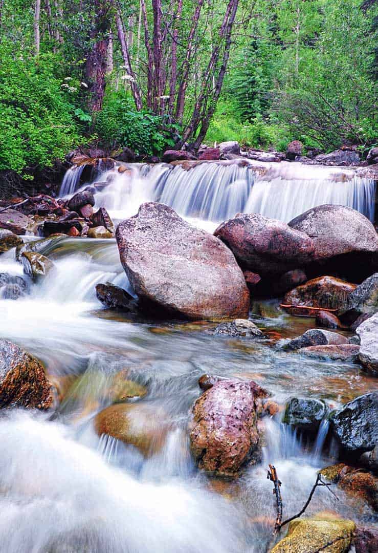 The rushing water of Pitkin Creek flows over several small waterfalls as it cascades down from 11,450' Pitkin Lake near Vail, CO.