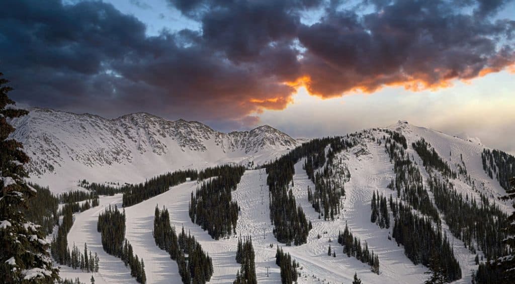 A late winter sunset lights up the clouds over Arapahoe Basin ski resort in Colorado.
