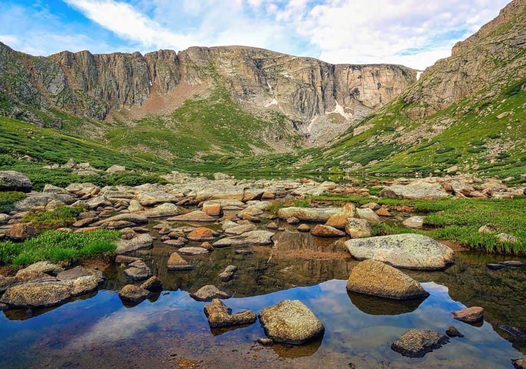 Crystal clear Upper Chicago Lake lies near the top of a broad valley at 11,733' in Colorado's Mt. Evans Wilderness. Just above the massive granite walls that partially encircle this boulder lined glacial lake are Mt. Evans (14,265'), Mt. Spalding (13,842'), and Mount Warren (13,307').