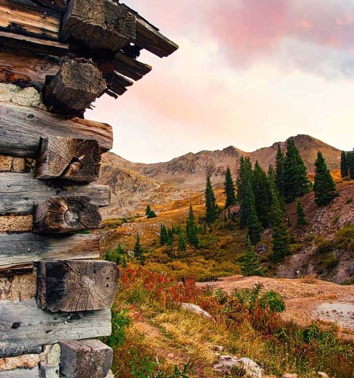 An interesting perspective of the Ten Mile Range under a colorful autumn sunset sky from one of several ruined mining cabins that make up what's left of the Old Boston Mine in the Mayflower Gulch area of Summit County, Colorado.