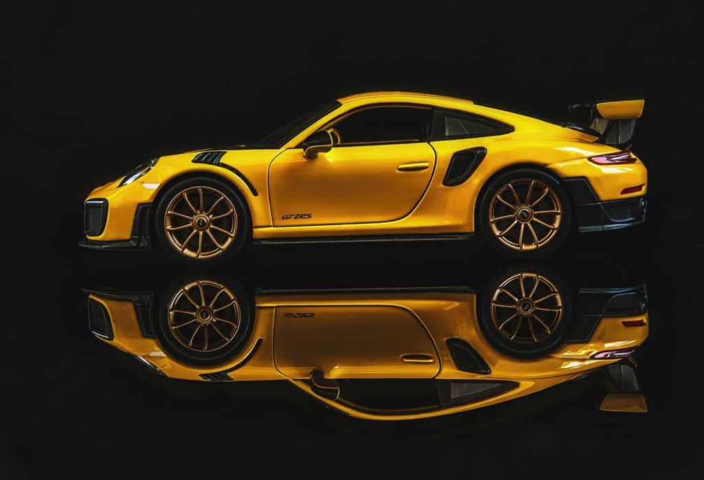 2018 Porsche 911 GT2 RS in signal yellow reflected against a black background