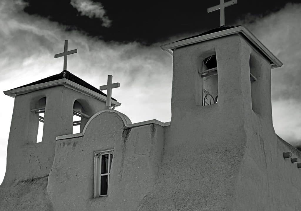 The historic San Francisco de Asis church in Rancho de Taos, New Mexico on a sunny late winter afternoon. With its twin bell towers and arched entry, this adobe church from the early 1800's blends Spanish colonial architecture and the building techniques of the Taos Pueblo people. Made famous by Ansel Adams and Georgia O'Keefe it is a National Historic Landmark and still an active church today.