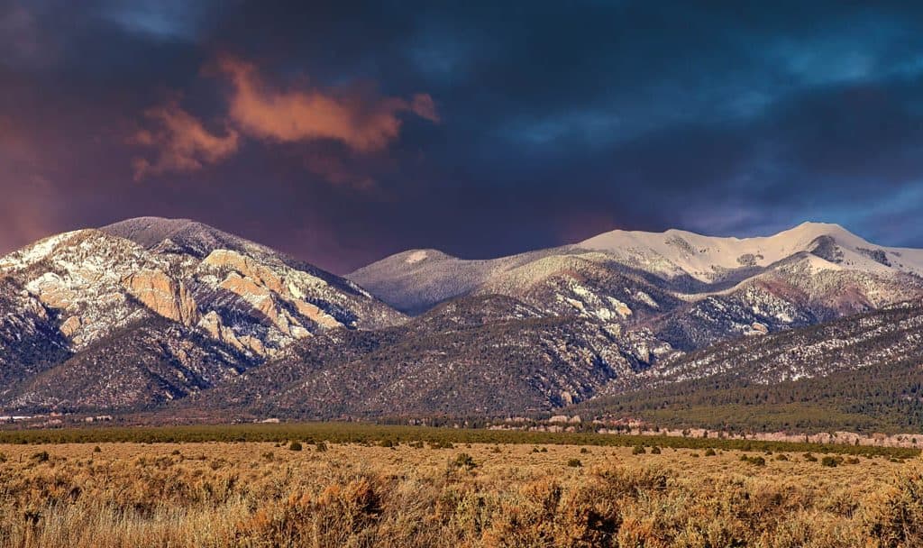 Colorful winter sunset over a snow capped Lucero Peak in the Sangre de Cristo Mountains outside Taos, New Mexico.