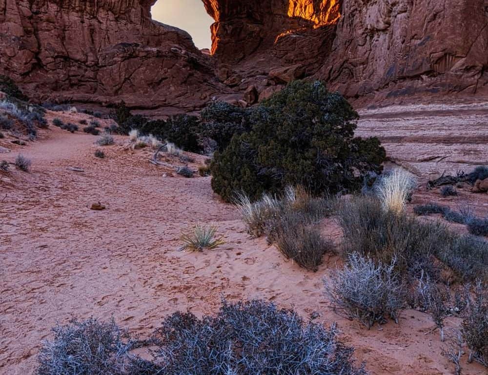 Double Arch in Arches National Park glowing at sunset.