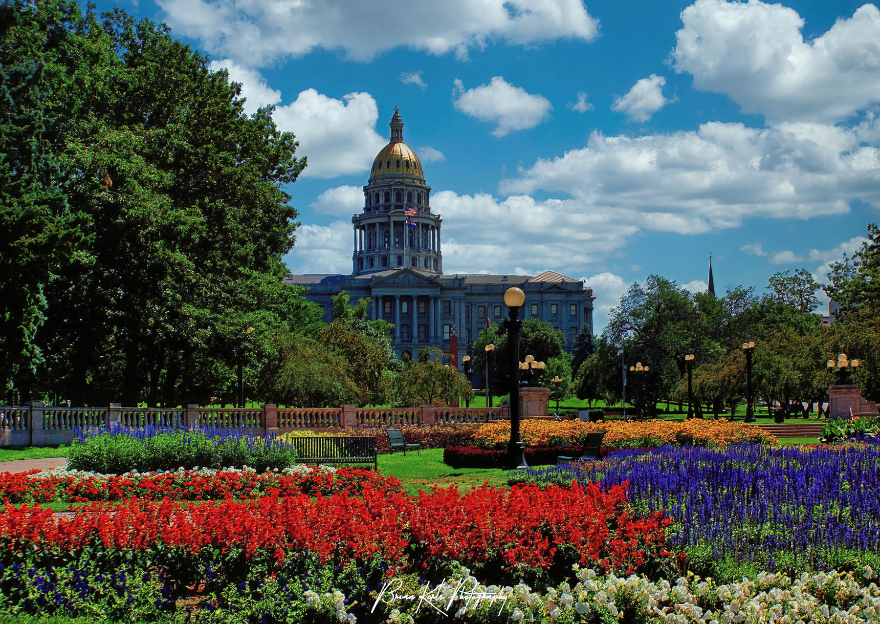 The gold domed Colorado State Capital Building in downtown Denver seen from the summer flower gardens of Civic Center Park.