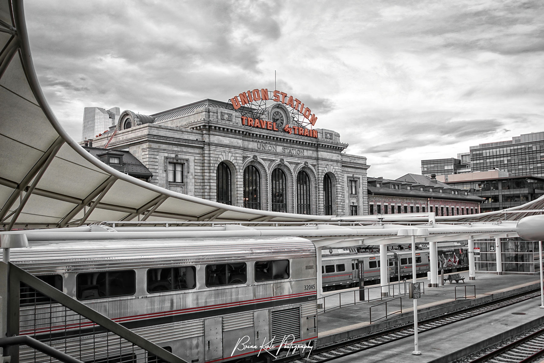 Black and white image with selective color highllights the distinctive modern structure of the new light rail concourse contrasts with original vintage Union Station facade on an early morning in downtown Denver, Colorado.