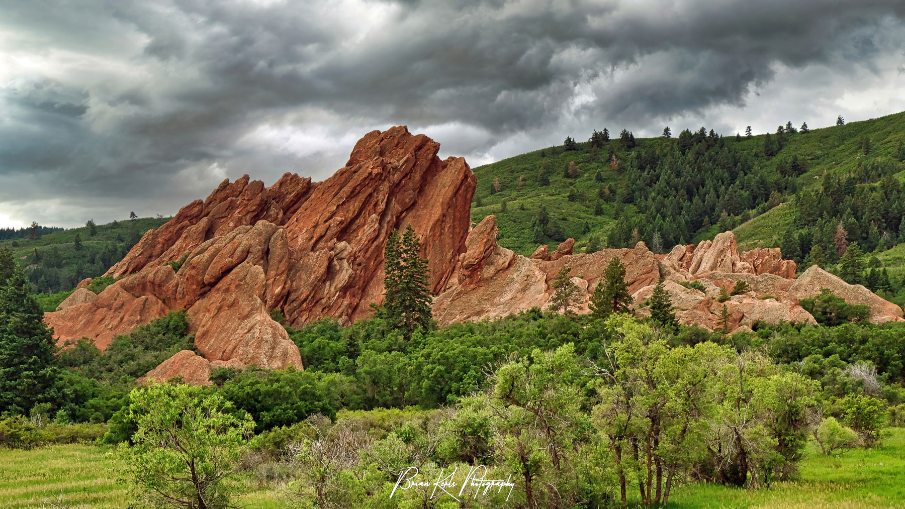 Dominated by impressive red sandstone rock formations, Roxborough State Park near Denver, Colorado has no shortage of amazing views. On this stormy afternoon the darkening sky is a wonderful contrast to the bright green foliage and striking red sandstone rock formations.