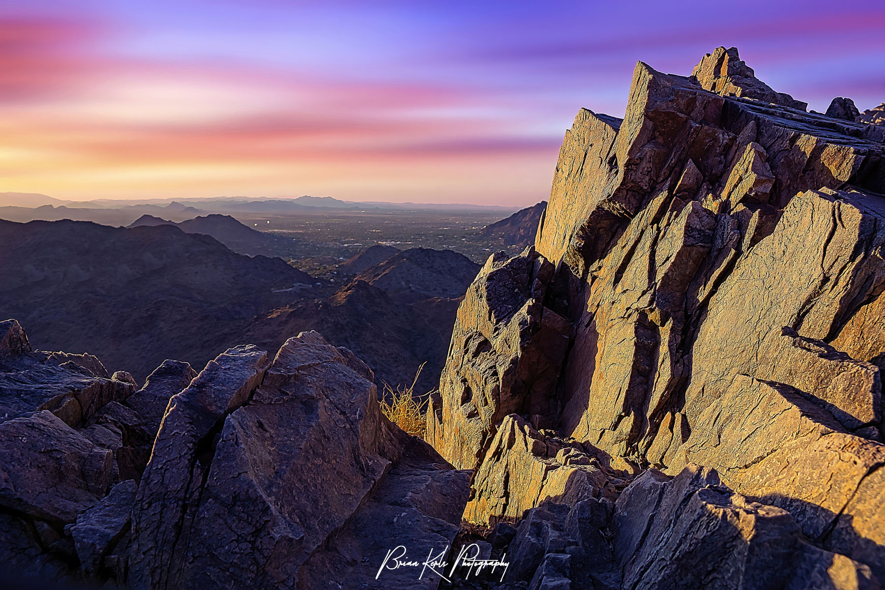 An amazingly colorful rainbow summer sunrise over the Phoenix Metro area framed by the rocky summit of Piestewa Peak. At 2,610 feet, Piestewa Peak is the 2nd highest peak in the Phoenix Mountains and named in honor of Army Spc. Lori Ann Piestewa, the first known Native American woman to die in combat in the U.S. military,and the first female soldier to be killed in action in the 2003 Iraq War.