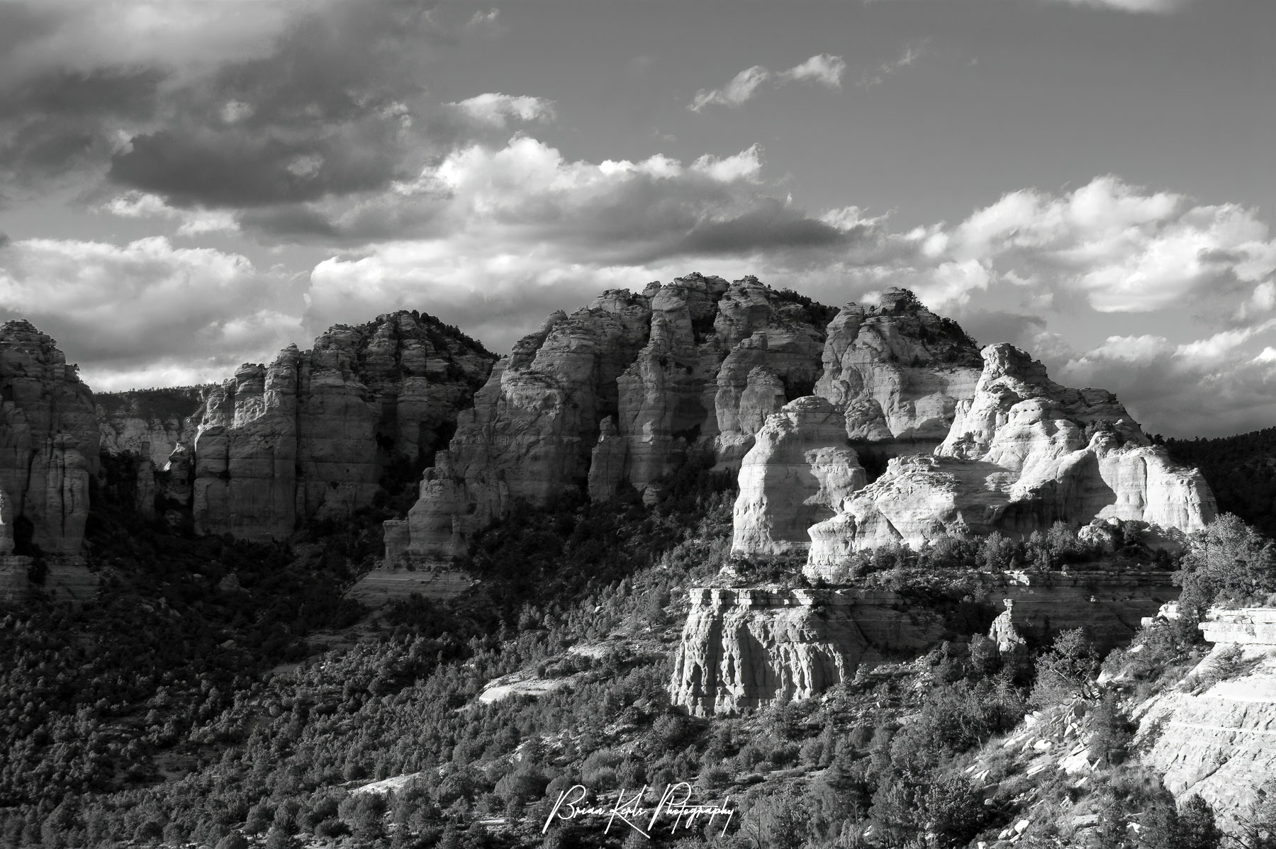 The setting sun illuminates the beautiful red rock cliffs, pillars, and formations outside of Sedona, Arizona on an autumn evening.