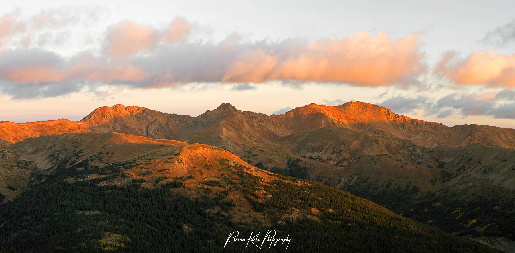 Early dawn light illuminates the peaks of the Rocky Mountains along the Continental Divide in Colorado. This multi-image sunrise panorama was shot on a crisp autumn morning from the summit of a neighboring 12,000' peak.