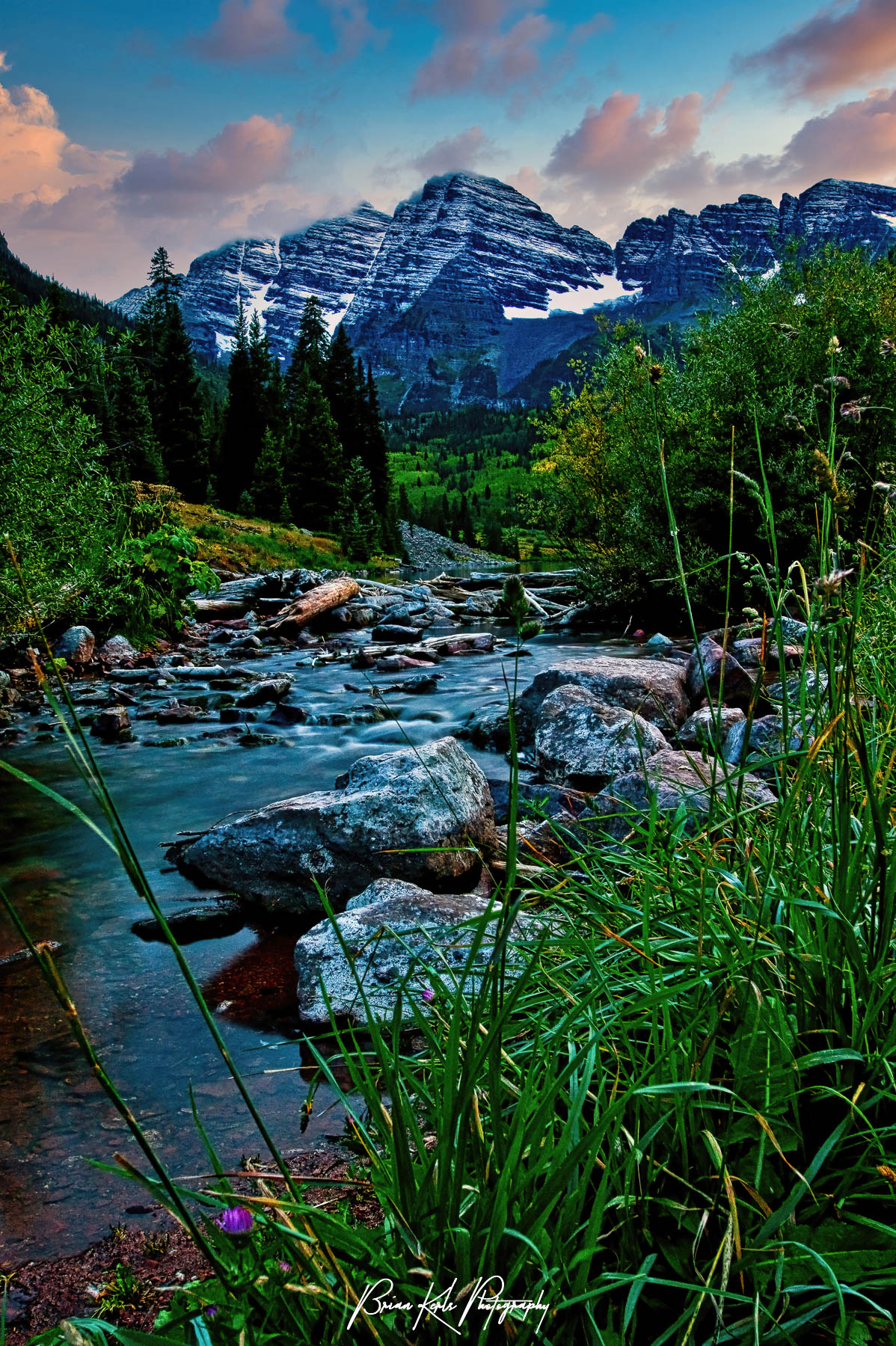 Some of the most photographed mountains in North America, the Maroon Bells are two distinctive, bell-shaped, wine-colored peaks rising 14,000 feet near Aspen, Colorado. Here I was able to capture these beautiful peaks under a colorful, autumn sunset sky with West Maroon Creek in the foreground.