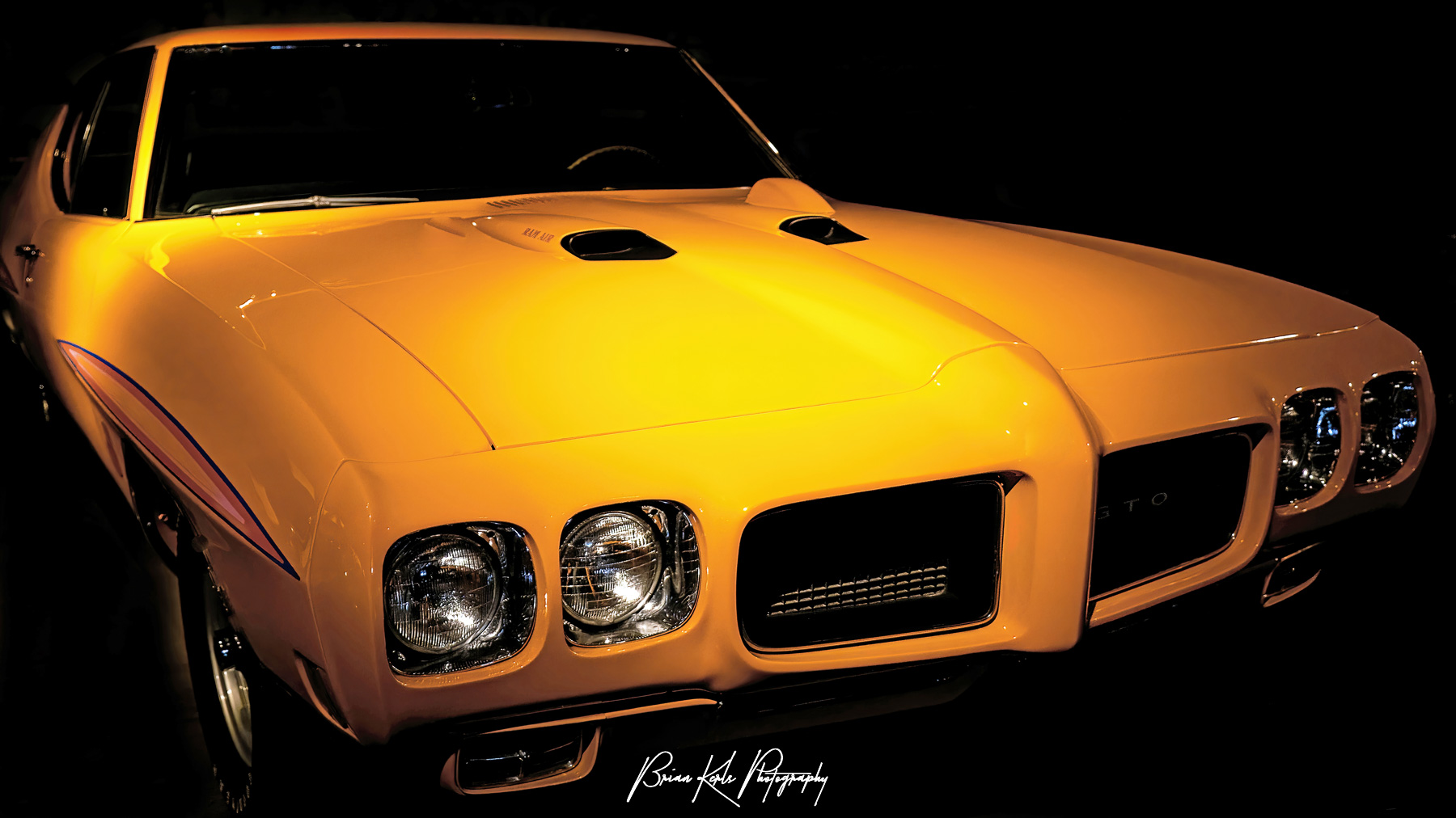 A fully restored 1970 Pontiac GTO "The Judge" in Orbit Orange with rare optional 455CID Ram Air engine, 4-speed, and hood tachometer.