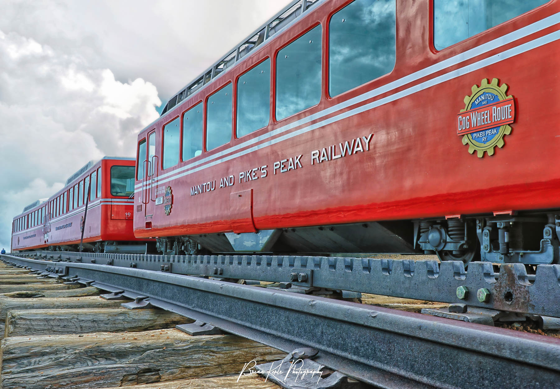 The bright red cars of the Pike's Peak Railway cog train at the summit of 14,115' Pike's Peak near Colorado Springs, Colorado. The railway runs 8.9 miles from Manitou Springs to the summit of Pike's Peak and gains over 7,700 feet in elevation.