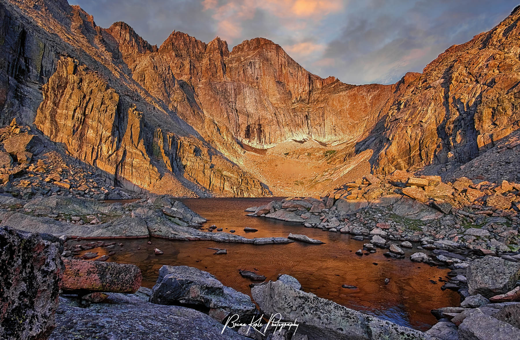 Located on the east side of Rocky Mountain National Park, Chasm Lake fills a deep cirque carved from the base of Mt. Meeker (13,911'), Longs Peak (14,259' and the highest point in the park), and Mt. Lady Washington (13,281'). The famous east-facing wall of Longs Peak known as "the diamond" rises 2,456' above this calm alpine lake which sits at 11,760'. Starting two hours before daybreak I made my way up the 4.2 miles to the lake mostly in the dark and arrived a little before sunrise and just in time to capture this image of the early morning summer light casting an orange glow on the peaks and surface of the water.