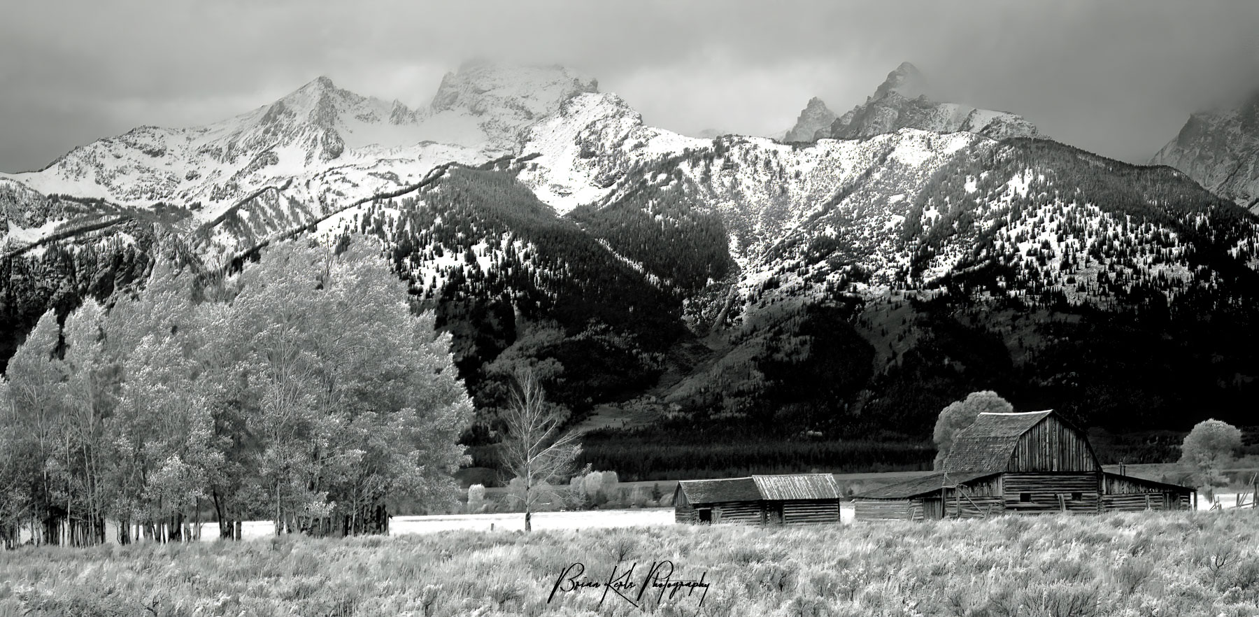 Approaching storm clouds shroud the peaks of the Teton Range with Moulton Barn in the foreground - Grand Teton National Park, Wyoming.