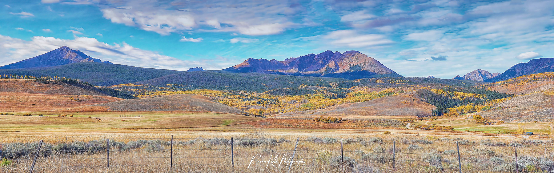 Colorful autumn hues blanket the rolling ranch land and forested hills at the foot of the Gore Range. This is three image panorama taken along Highway 9 north of Silverthorne, Colorado.