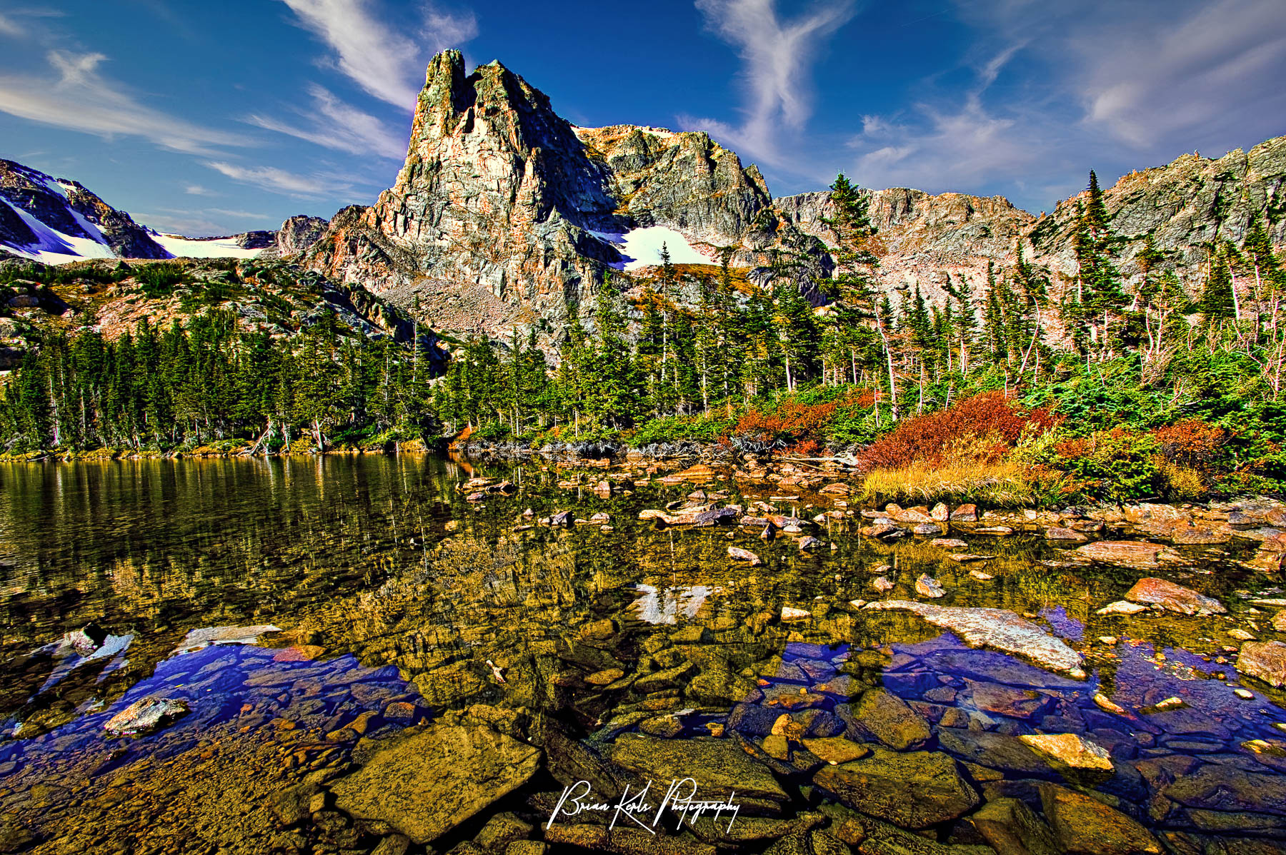 The clear water of Lake Helene, with Notchtop Mountain standing tall in the background on a fall morning in Rocky Mountain National Park, Colorado.