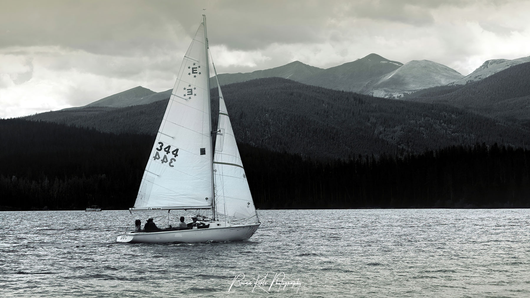 Lone sailboat crosses high altitude Lake Dillon in Summit County Colorado.