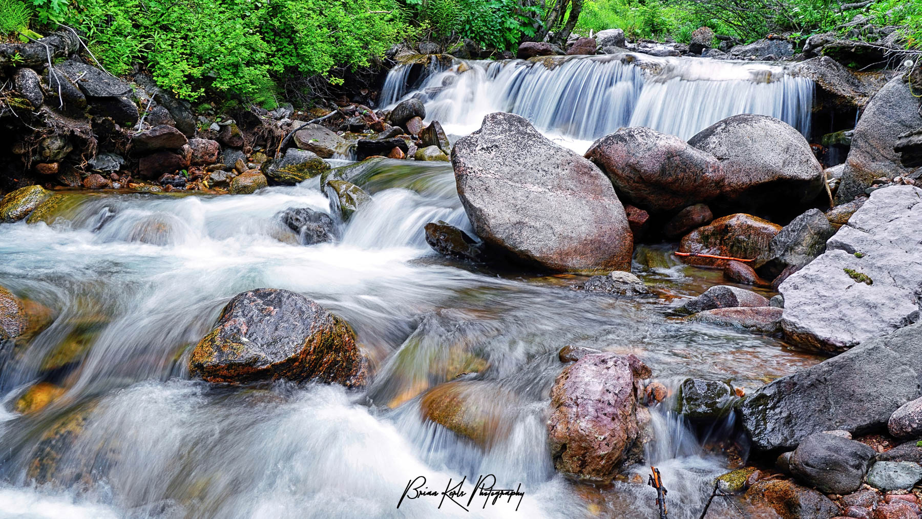 The rushing water of Pitkin Creek flows over several small waterfalls as it cascades down from 11,450' Pitkin Lake near Vail, CO.