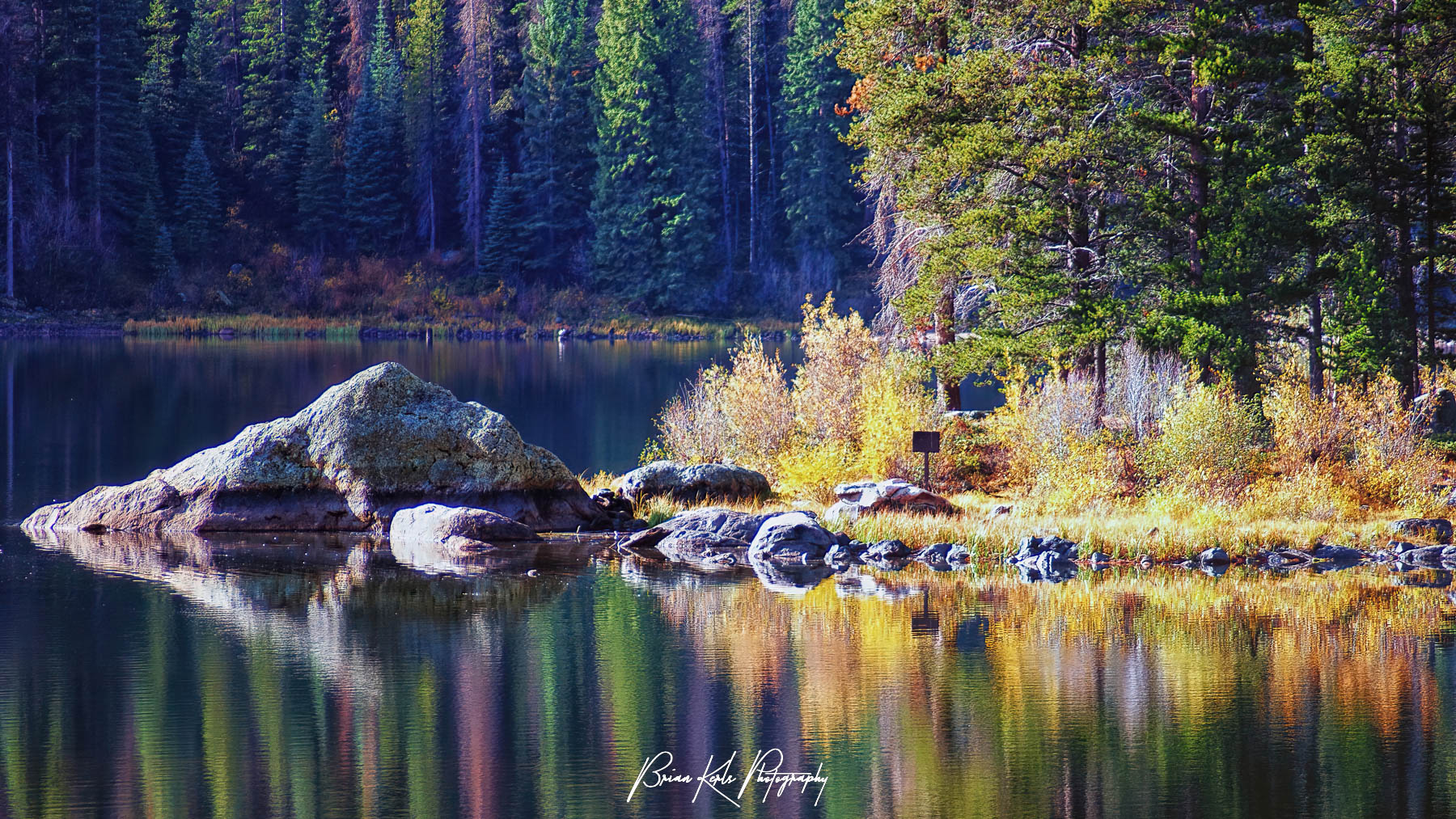 Monarch Lake reflects autumn colors of shoreline on early fall morning.