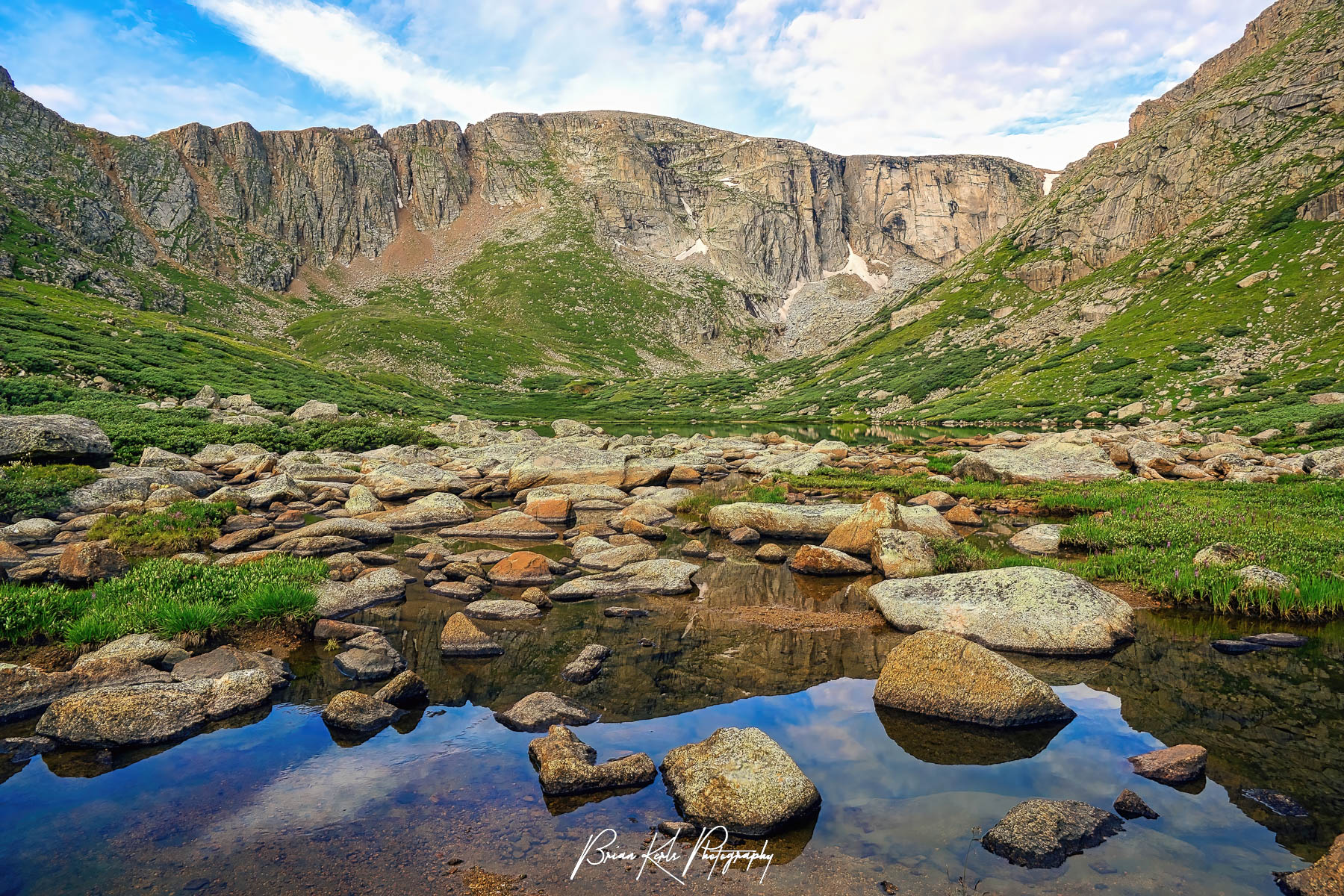 Crystal clear Upper Chicago Lake lies near the top of a broad valley at 11,733' in Colorado's Mt. Evans Wilderness. Just above the massive granite walls that partially encircle this boulder lined glacial lake are Mt. Evans (14,265'), Mt. Spalding (13,842'), and Mount Warren (13,307').