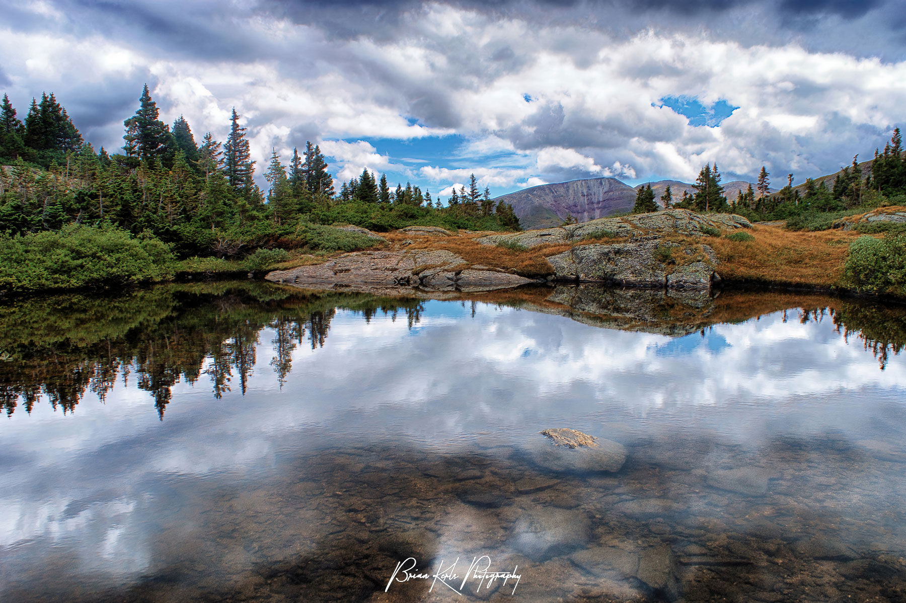 Afternoon clouds rolling in over the Ten Mile Range are reflected in the glassy water of Mohawk Lake in Summit County Colorado.