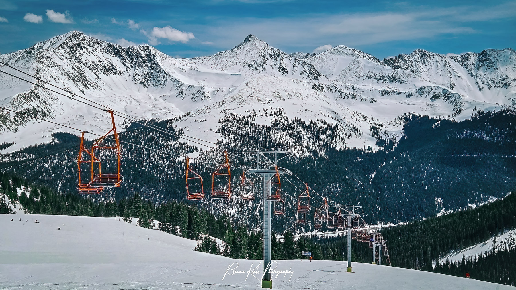 Blackjack chairlift at Copper Mountain Ski Resort with peaks of the Ten Mile and Mosquito Ranges in the distance.