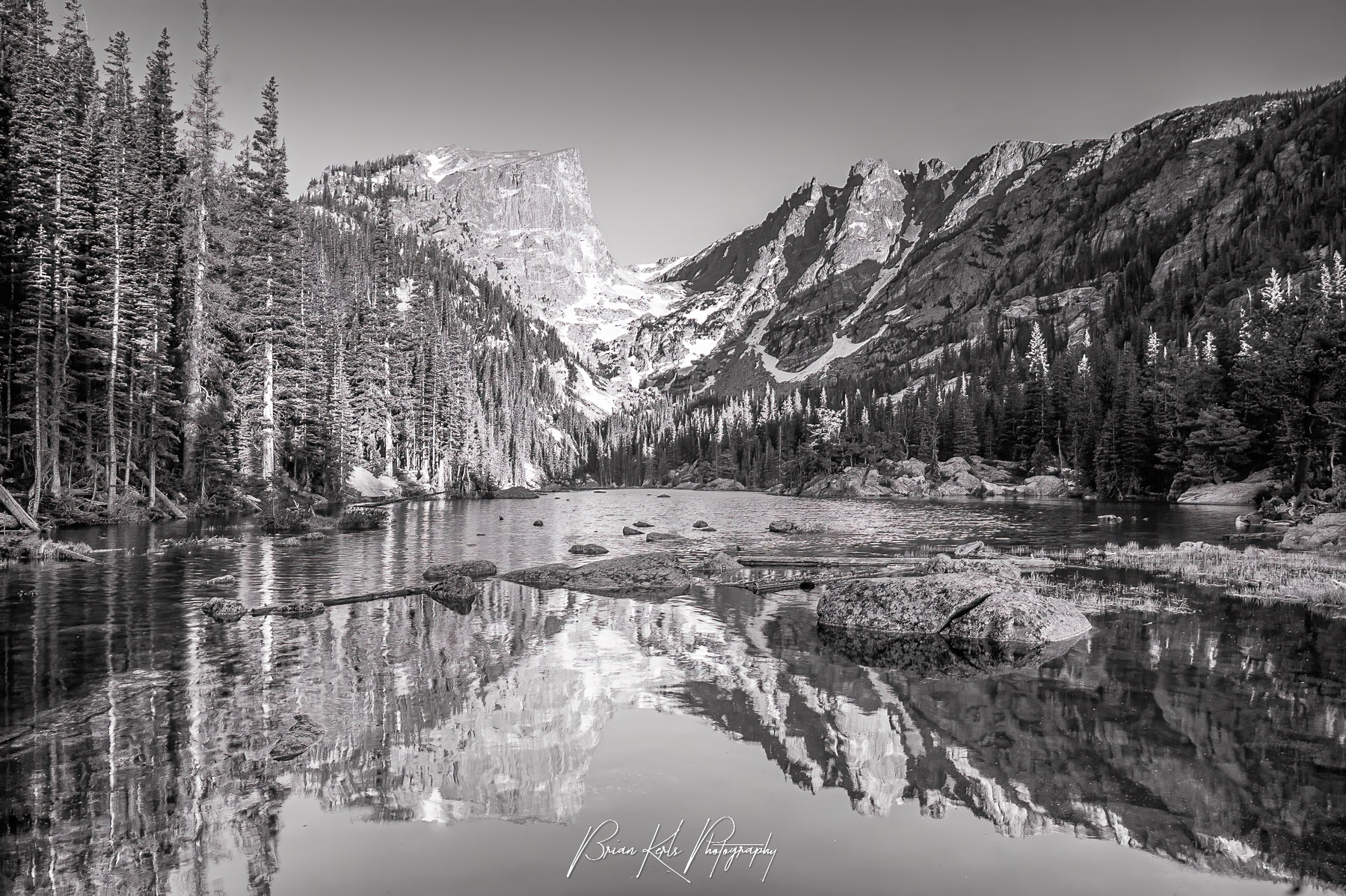 Black and white mountain photograph of Hallet Peak reflected in glassy water of Dream Lake in Rocky Mountain National Park, Colorado