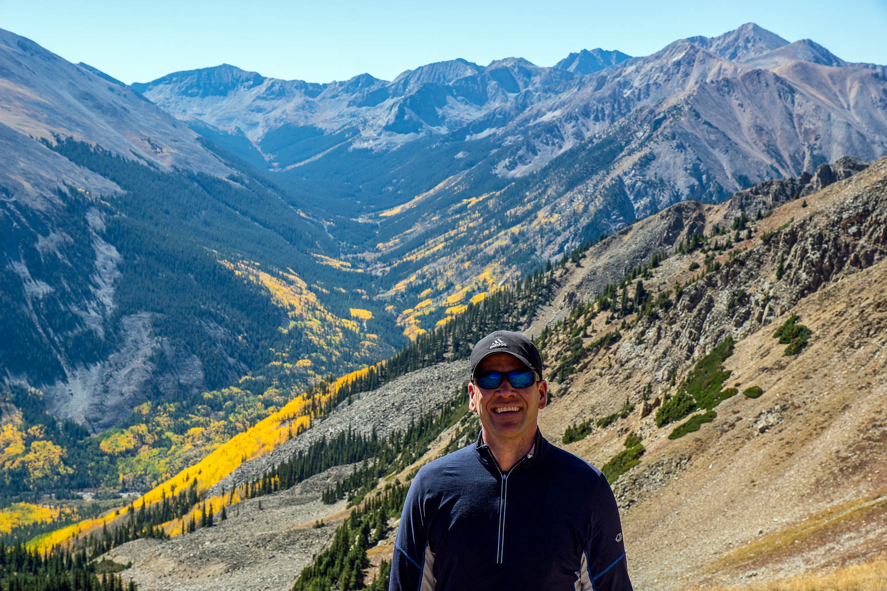 Brian in front of a dramatic Colorado vista, capturing beautiful fall foliage and distant rugged mountain peaks - landscape photographer specializing in images of Colorado, the American Southwest, Pacific Coast, and iconic National Parks.